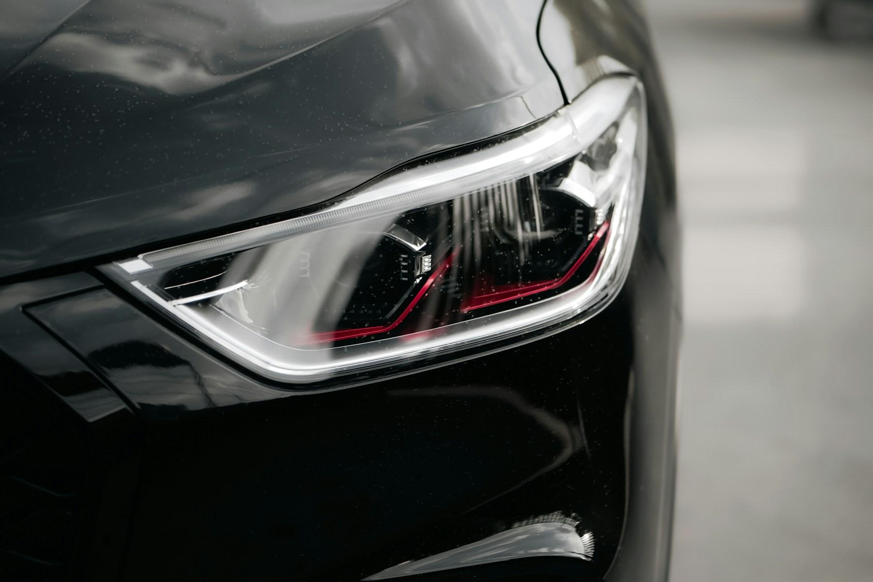 Detailed headlight and sculpted front body panel of a car